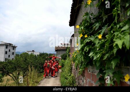 Nanfeng, province de Jiangxi en Chine. 23 juillet, 2015. Les enfants vont à l'ancestral hall pour pratiquer la danse au Village Nuo Shiyou, Sanxi Canton de Nanfeng County, province de Jiangxi, Chine orientale, le 23 juillet 2015. Danse Nuo utilisée pour être les rituels sacrificiels dans la Chine ancienne pour expulser les esprits mauvais et prier pour de bonnes récoltes. Il y a environ une décennie, vous Genming, un héritier de Nuo danse, mis en place une classe d'une adolescente du Village de poursuivre Shiyou Nuo danse, qui est reconnue comme étant 'le fossile vivant de l'ancienne danse chinoise' . © Chen Zixia/Xinhua/Alamy Live News Banque D'Images