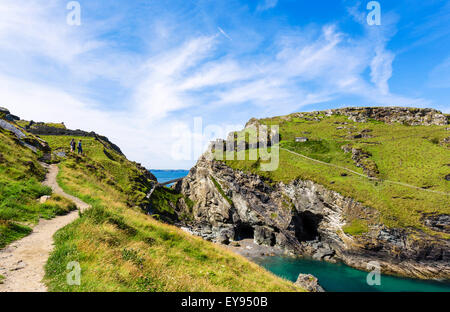 Les promeneurs sur un chemin à travers des ruines du château de Tintagel, un site lié à la légende du Roi Arthur, Cornwall, England, UK Banque D'Images