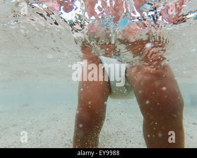 Bébé en couches dans des eaux peu profondes au-dessous de la surface de la mer, la photographie sous-marine. Banque D'Images