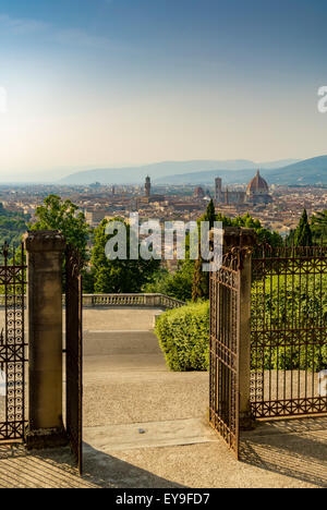 Vue sur Florence vue à travers les portes ouvertes du sommet de la colline, église San Miniato al Monte et monastère. Florence, Italie. Banque D'Images