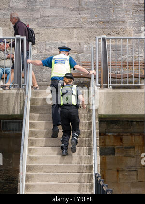 Un agent de soutien communautaire de la police et d'une dame de la police montée des escaliers tout en en patrouille Banque D'Images