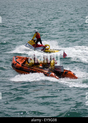 Les sauveteurs RNLI équitation une côte et un scooter dans la mer Banque D'Images