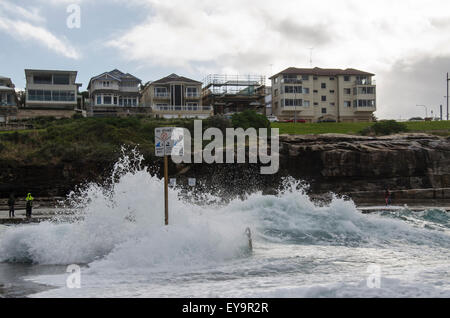 Une grande vague couvre presque un panneau d'interdiction de plongée à Clovelly Beach à Sydney, en Australie, pendant le temps orageux Banque D'Images