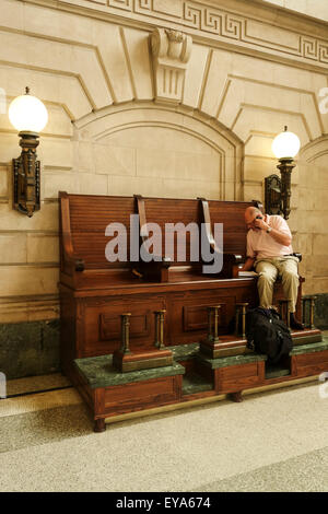 Business man sitting in American service de cireur chaise, Hoboken, historique salle d'attente, Train Terminal, New Jersey, USA. Banque D'Images