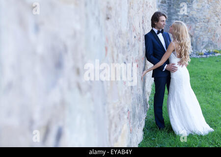 Couple marié romantique ressemble partage plein d'amour, s'appuyant sur un mur. Banque D'Images