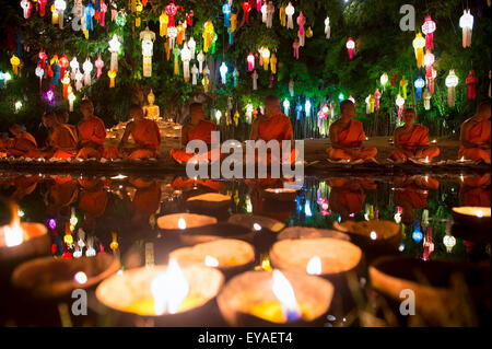 CHIANG MAI, THAÏLANDE - 06 NOVEMBRE 2014 : Bougies flotter en face de jeunes moines bouddhistes méditant dans un festival de lumières. Banque D'Images