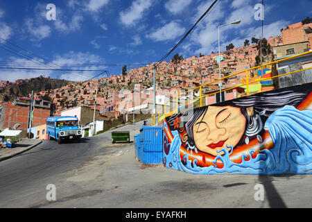 Murale sur le mur dans la banlieue de la ville sur une colline abrupte, typique vieux micro-bus bleu utilisé comme les transports publics en arrière-plan, la Paz, Bolivie Banque D'Images