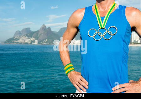 RIO DE JANEIRO, Brésil - Mars 05, 2015 : athlète signifie porter anneaux olympiques médaille d'or en face de vue sur l'horizon d'Ipanema. Banque D'Images