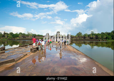 Vue panoramique sur le temple d'Angkor Wat complexe avec les touristes sur l'entrée du pont-jetée au-dessus de la douve entourant Banque D'Images