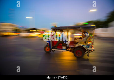 Taxi tuk-tuk colorés par les zooms dans un flou en début de soirée à Bangkok, Thaïlande Banque D'Images