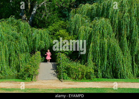 Jeune fille sur le pont de pieds au-dessus de la River Test à Mottisfon Abbeyt, une propriété de National Trust dans le Hampshire, Angleterre Royaume-Uni Banque D'Images