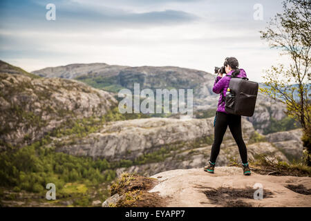 Photographe Nature touriste avec appareil photo shoots en se tenant sur le haut de la montagne. La belle nature de la Norvège. Banque D'Images