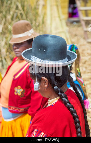 Îles flottantes, Lac Titicaca, Puno, Pérou. Femme avec des tresses, portant un chapeau melon noir traditionnel sur Isla Apu Inti Banque D'Images