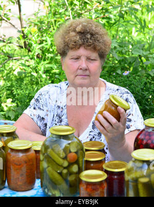 Femme au foyer mature avec une nourriture en conserve pour l'hiver Banque D'Images