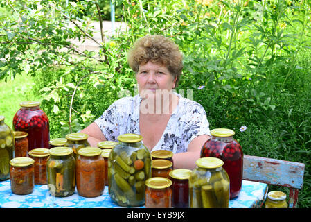 Femme au foyer mature avec une nourriture en conserve pour l'hiver Banque D'Images