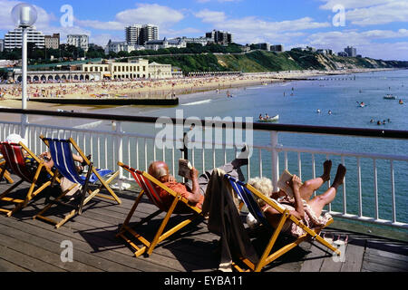 Le soleil dans des chaises longues sur la jetée de Bournemouth. Le Dorset. L'Angleterre. UK Banque D'Images