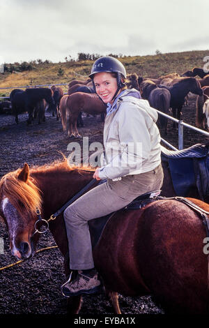 Une jeune femme à cheval en attendant de s'élancer sur un cheval islandais tour. L'Islande Banque D'Images