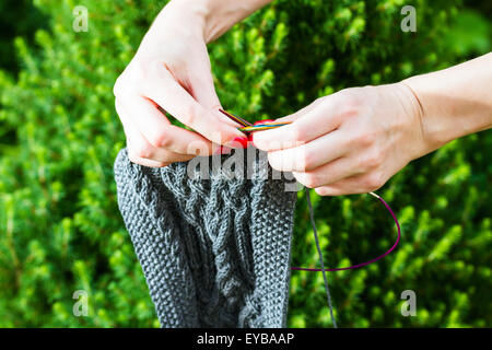 Écharpe en laine faits à la main et la femme les mains sur fond de sapins Banque D'Images