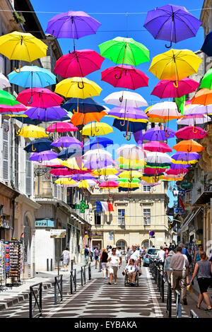 Ciel bleu et soleil couleurs parapluie street art ville antique d'Arles France Provence cast shadow répétitives d'évolution au sein de la rue commerçante Banque D'Images