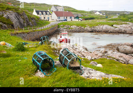 Petit bateau de pêche et des casiers à homard sur la côte est de Barra, îles Hébrides, Ecosse, Royaume-Uni Banque D'Images