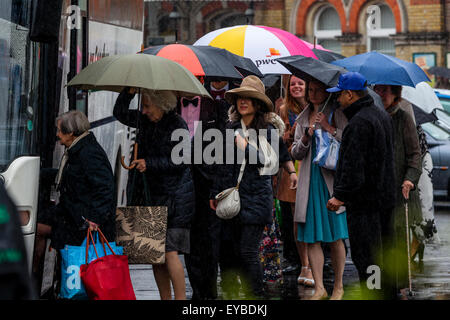 Lewes, dans le Sussex, UK. 26 juillet, 2015. Les gens arrivent à la gare de Lewes et File d'attente sous la pluie battante pour le transport à l'opéra de Glyndebourne à proximité pour regarder la performance d'aujourd'hui de Saül. Credit : Grant Rooney/Alamy Live News Banque D'Images