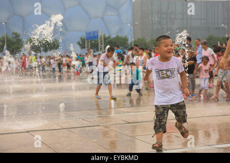 Les enfants chinois s'amusant à jouer parmi les têtes à l'eau le Parc olympique de Beijing - Juillet 2015 Banque D'Images