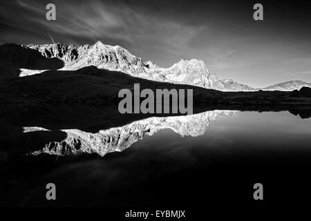 Réflexions sur le lac Buse Basse. Le groupe de montagne Lagorai. Région Trentin. Alpes italiennes. Europe. Noir blanc paysage. Banque D'Images