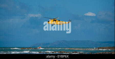 Un Sea King RAF jaune emeregency hélicoptère de sauvetage air-mer et de sauvetage au large des côtes de la pêche côtière de la RNLI Aberystwyth Wales UK Banque D'Images