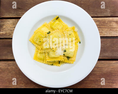 Repas dans un pub rempli de pâtes Raviolis aux épinards et ricotta avec du beurre poivre noir et Parmesan émietté Banque D'Images