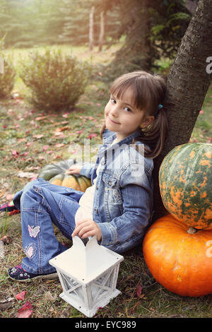 Fille est basé sur un arbre en une journée ensoleillée d'automne Banque D'Images