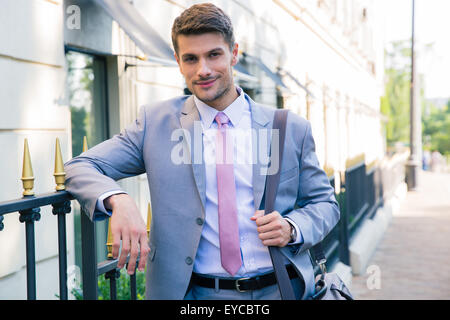 Portrait of a smiling handsome businessman standing outdoors and looking at camera Banque D'Images