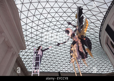 Londres, Royaume-Uni. 27 juillet 2015. Photo : Musée britannique Kate employé Morais tend la main à une sculpture. Dans le cadre de la célébration de l'Afrique" au Musée Britannique le Royaume-uni-trinidadien artiste Zak Ové a créé deux Moko Jumbie sculptures. Sept mètres de haut de l'Ove chiffres carnaval sur pilotis sont affichés dans la Grande Cour du 28 juillet au 13 septembre 2015. Les hommes et les chiffres sont inspirés par la mascarade de l'Afrique et ont été commandées afin de coïncider avec le carnaval de Notting Hill à la fin du mois d'août. Banque D'Images