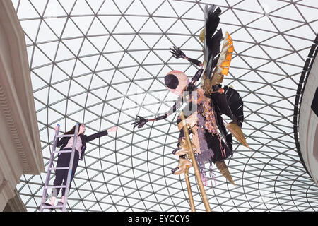 Londres, Royaume-Uni. 27 juillet 2015. Photo : Musée britannique Kate employé Morais tend la main à une sculpture. Dans le cadre de la célébration de l'Afrique" au Musée Britannique le Royaume-uni-trinidadien artiste Zak Ové a créé deux Moko Jumbie sculptures. Sept mètres de haut de l'Ove chiffres carnaval sur pilotis sont affichés dans la Grande Cour du 28 juillet au 13 septembre 2015. Les hommes et les chiffres sont inspirés par la mascarade de l'Afrique et ont été commandées afin de coïncider avec le carnaval de Notting Hill à la fin du mois d'août. Banque D'Images