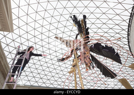 Londres, Royaume-Uni. 27 juillet 2015. Photo : Musée britannique Kate employé Morais tend la main à une sculpture. Dans le cadre de la célébration de l'Afrique" au Musée Britannique le Royaume-uni-trinidadien artiste Zak Ové a créé deux Moko Jumbie sculptures. Sept mètres de haut de l'Ove chiffres carnaval sur pilotis sont affichés dans la Grande Cour du 28 juillet au 13 septembre 2015. Les hommes et les chiffres sont inspirés par la mascarade de l'Afrique et ont été commandées afin de coïncider avec le carnaval de Notting Hill à la fin du mois d'août. Banque D'Images