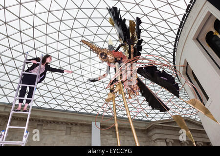 Londres, Royaume-Uni. 27 juillet 2015. Photo : Musée britannique Kate employé Morais tend la main à une sculpture. Dans le cadre de la célébration de l'Afrique" au Musée Britannique le Royaume-uni-trinidadien artiste Zak Ové a créé deux Moko Jumbie sculptures. Sept mètres de haut de l'Ove chiffres carnaval sur pilotis sont affichés dans la Grande Cour du 28 juillet au 13 septembre 2015. Les hommes et les chiffres sont inspirés par la mascarade de l'Afrique et ont été commandées afin de coïncider avec le carnaval de Notting Hill à la fin du mois d'août. Banque D'Images