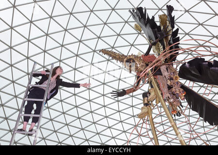 Londres, Royaume-Uni. 27 juillet 2015. Photo : Musée britannique Kate employé Morais tend la main à une sculpture. Dans le cadre de la célébration de l'Afrique" au Musée Britannique le Royaume-uni-trinidadien artiste Zak Ové a créé deux Moko Jumbie sculptures. Sept mètres de haut de l'Ove chiffres carnaval sur pilotis sont affichés dans la Grande Cour du 28 juillet au 13 septembre 2015. Les hommes et les chiffres sont inspirés par la mascarade de l'Afrique et ont été commandées afin de coïncider avec le carnaval de Notting Hill à la fin du mois d'août. Banque D'Images