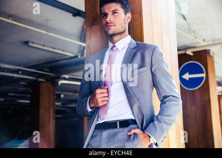 Portrait of a smiling businessman standing in parking souterrain Banque D'Images