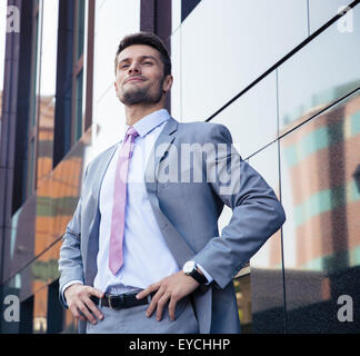 Portrait of a happy confident businessman in suit standing outdoors Banque D'Images