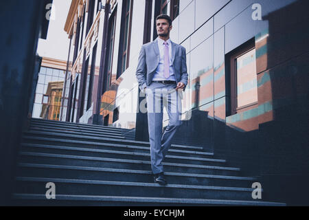 Portrait of a handsome businessman walking réfléchies sur l'escalier extérieur Banque D'Images