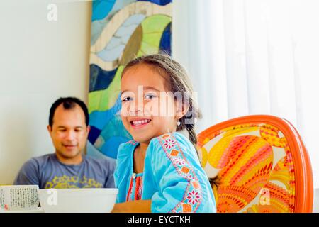 Portrait de jeune fille assise à table avec le père Banque D'Images