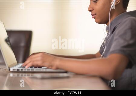 Cropped shot of woman at table à manger typing on laptop Banque D'Images