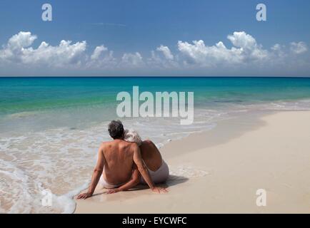 Senior couple sitting on beach, Maldives Banque D'Images
