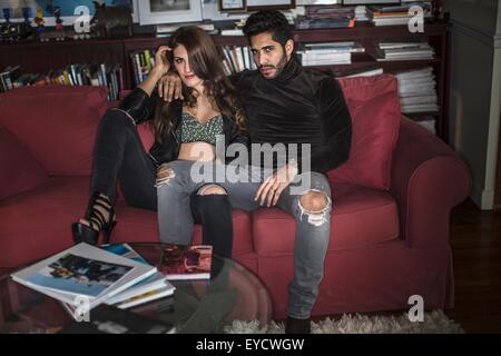 Young couple sitting on sofa Banque D'Images