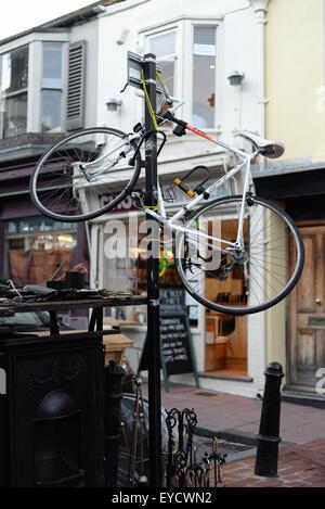 Vélo verrouillé à un poste dans une rue à Brighton Banque D'Images