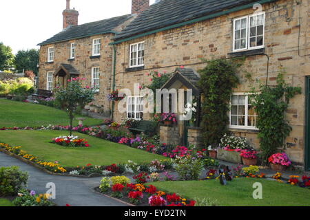 Construit en pierre traditionnelle britannique chalets avec jardin immaculé dans une succession de frontières English Village, South Yorkshire, Angleterre, Royaume-Uni Banque D'Images