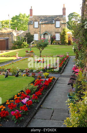 Maisons en pierre traditionnelle, pristine surround jardins en une région rurale de la village, England UK - été 2015 Banque D'Images