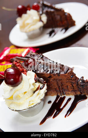 Une tranche de gâteau au chocolat et crème. Il y a un autre en arrière-plan. Banque D'Images