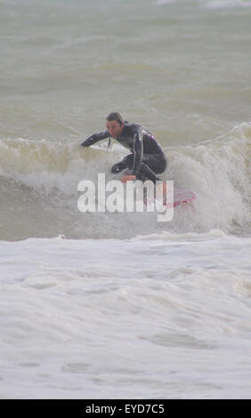 Shoreham, East Sussex, Royaume-Uni. 27 Juillet 2015. Le surfeur se met à une vague au large de Southwick Beach Banque D'Images