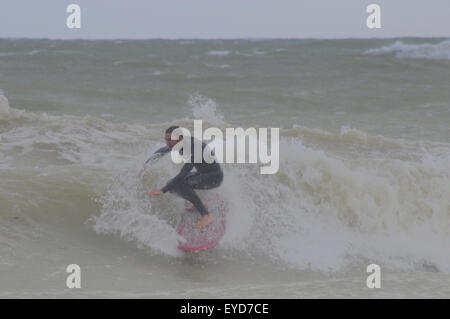 Shoreham, East Sussex, Royaume-Uni. 27 Juillet 2015. Le surfeur se met à une vague au large de Southwick Beach Banque D'Images