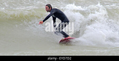 Shoreham, East Sussex, Royaume-Uni. 27 Juillet 2015. Le surfeur se met à une vague au large de Southwick Beach Banque D'Images